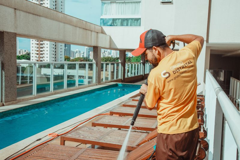 Colaborador do Grupo Distrital limpando área de piscina em condomínio vertical